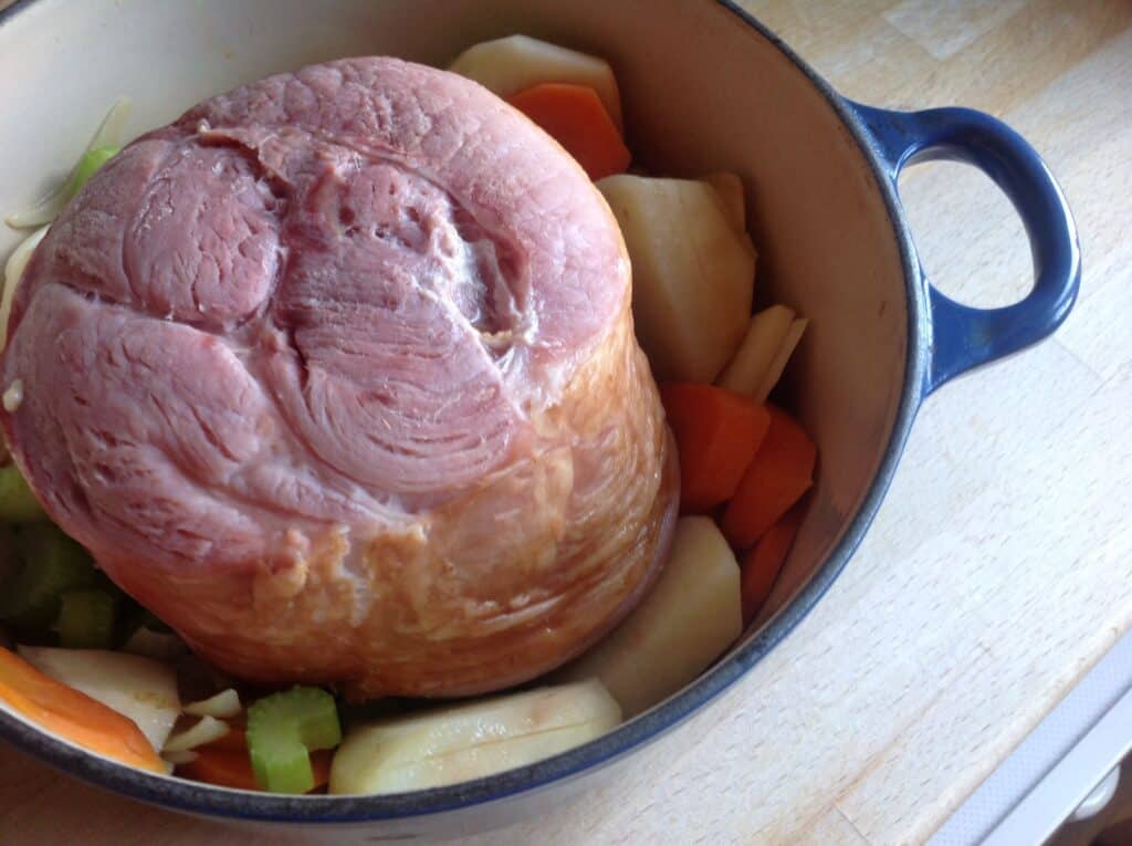 boiled bacon in the cooking pot with vegetables