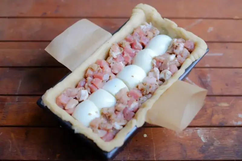an assembled uncooked gala pie showing the egg column