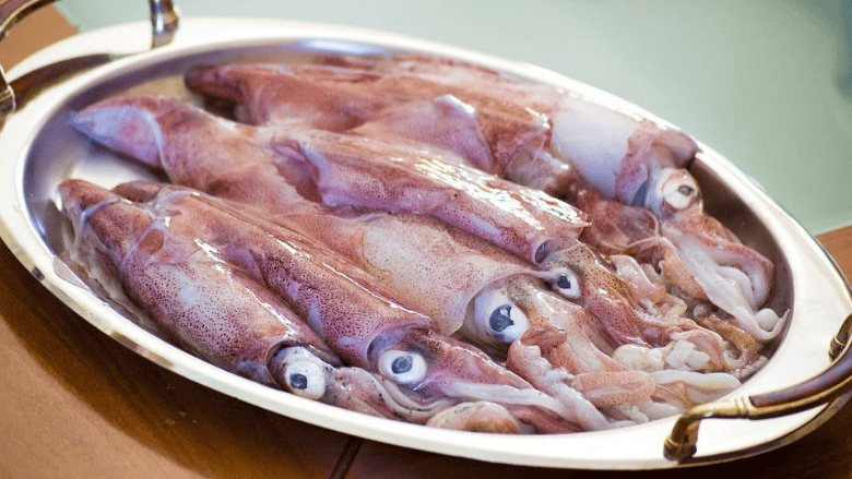 several raw squid on a platter